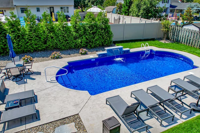 Chush H - Hamilton, NJ - A backyard with a swimming pool surrounded by a fence and landscaping.