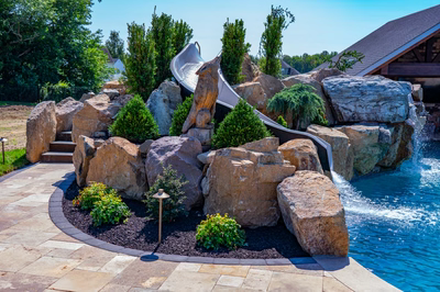 Cispus G - Mantua, NJ - A large rock garden with a water feature and a water slide in a backyard setting