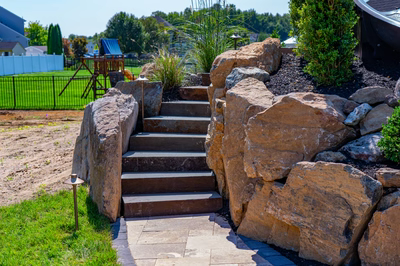 Cispus I - Mantua, NJ - A stone retaining wall with steps leading up to a play area.