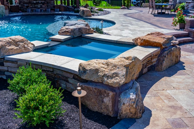 Cispus P - Mantua, NJ - A backyard with a swimming pool surrounded by rocks and landscaping