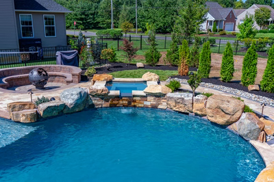 Cispus R - Mantua, NJ - A backyard with a swimming pool surrounded by landscaping and a fire pit