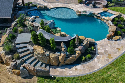 Cispus W - Mantua, NJ - A backyard with a swimming pool surrounded by landscaping and a water feature