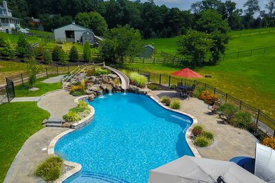 Clarendon G - Cream Ridge, NJ - A large backyard with a swimming pool and a water feature, surrounded by lush green grass and trees