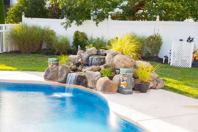 Clearwater B - Hainesport, NJ - A backyard with a swimming pool and a waterfall feature
