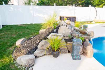 Clearwater D - Hainesport, NJ - A backyard with a pool and a rock waterfall feature.