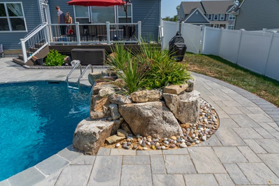 Cliff E - Bel Aire, MD - A backyard with a swimming pool and a stone waterfall feature