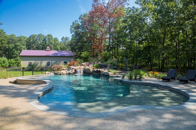 Coal E - Vincentown, NJ - A large rectangular swimming pool surrounded by lush greenery and a small house in the background
