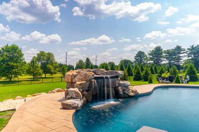 Comet C - Medford, NJ - A swimming pool with a waterfall in the middle of it surrounded by lush green grass and trees