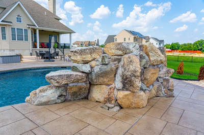 Comet G - Medford, NJ - A large rock wall next to a swimming pool in a backyard.