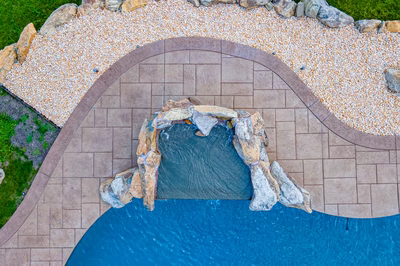 Comet H - Medford, NJ - A bird's eye view of a swimming pool with a waterfall and a stone pathway