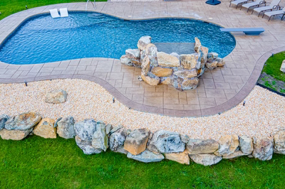 Comet I - Medford, NJ - A rectangular swimming pool surrounded by a stone retaining wall and lush green grass