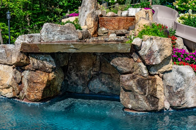 Copper F - Cream Ridge, NJ - A rock waterfall in a swimming pool surrounded by flowers and greenery