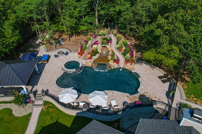 Copper N - Cream Ridge, NJ - A bird's eye view of a backyard with a swimming pool and a waterfall surrounded by lush greenery