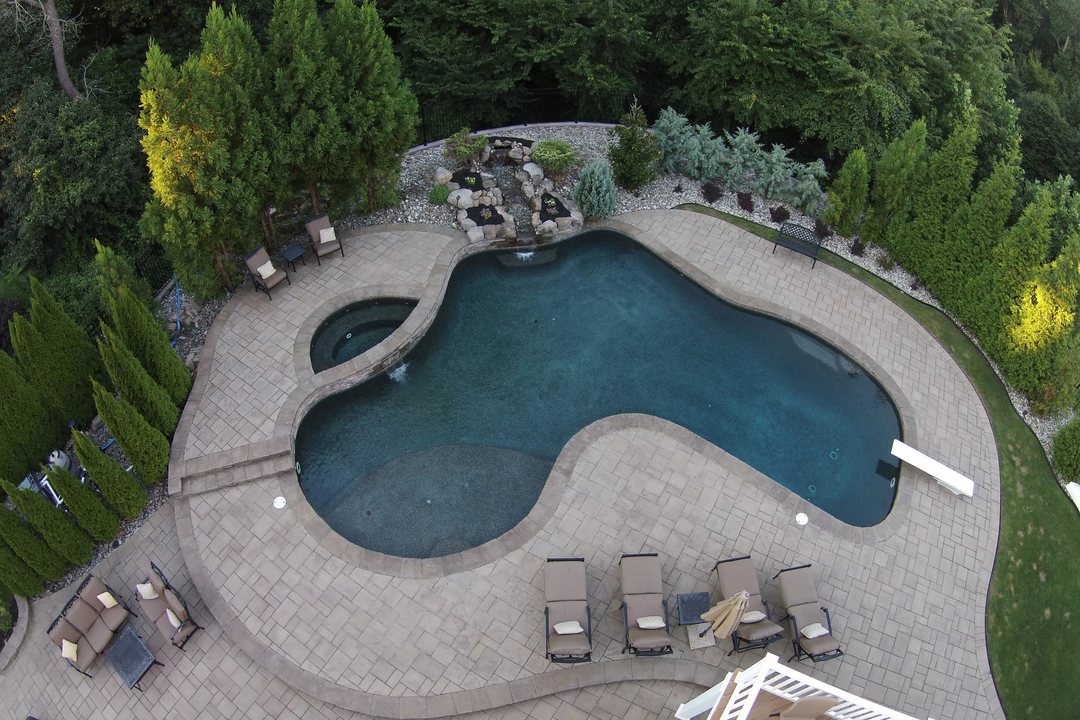 Cummins I - Laurel Springs, NJ - A bird's eye view of a backyard with a swimming pool surrounded by lush greenery