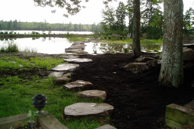 Dagg G - New Jersey - A stone path leading to a lake surrounded by trees and grass.