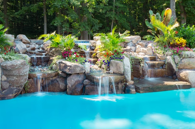Daintree D - Spring City, NJ - A beautiful outdoor swimming pool surrounded by lush greenery and colorful flowers