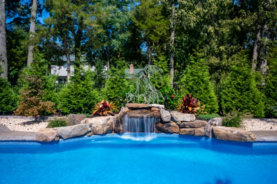 Datanla A - Brick, NJ - A swimming pool with a waterfall in the middle surrounded by lush greenery