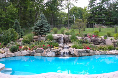 Dawa B - Bedminster, NJ - A swimming pool surrounded by lush greenery and a waterfall.