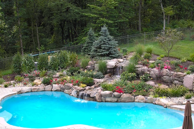 Dawa G - Bedminster, NJ - A backyard with a swimming pool surrounded by lush greenery and flowers