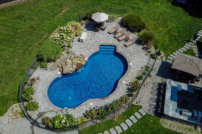 Decorah I - Wall, NJ - A bird's eye view of a backyard with a swimming pool surrounded by landscaping