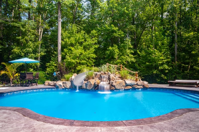 Desoto G - Perryville, MD - A swimming pool surrounded by lush greenery with a waterfall feature