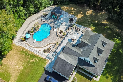 Desoto H - Perryville, MD - A bird's eye view of a large backyard with a swimming pool surrounded by lush greenery
