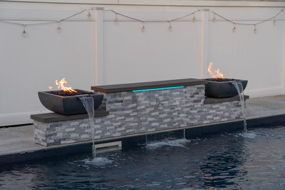 Dune D - Brigantine, NJ - A fire pit sitting on top of a stone wall next to a pool.