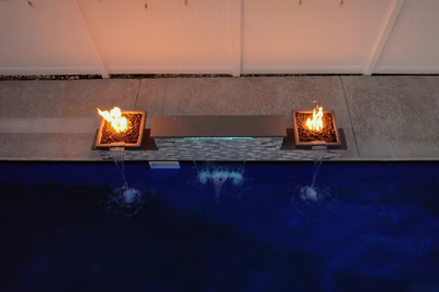 Dune H - Brigantine, NJ - A fire pit sitting on top of a concrete wall next to a swimming pool at night