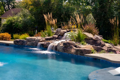 Elowah E - Collegeville, PA - A swimming pool with a waterfall in the middle surrounded by lush greenery