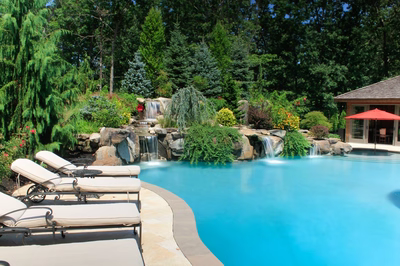 Flume C - Franklinville, NJ - A swimming pool surrounded by lush greenery and a waterfall.