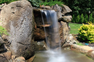 Flume D - Franklinville, NJ - A small waterfall cascades over large rocks in a lush garden setting