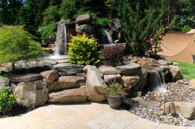 Flume E - Franklinville, NJ - A beautiful garden with a waterfall feature surrounded by lush greenery and flowers