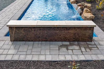 Formal B - Forrest Hills, MD - A rectangular pool with a waterfall in the middle surrounded by stone pavers