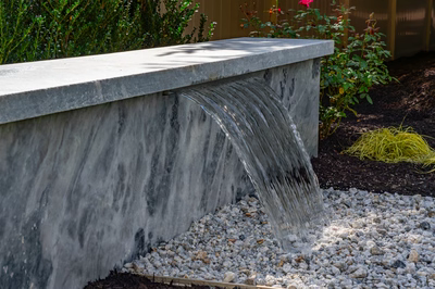 Formal G -  - A concrete bench with a water feature in a garden setting