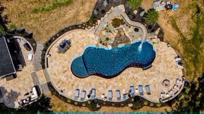 Gavarnie R - Monkton, MD - A backyard with a pool and a waterfall surrounded by lush greenery