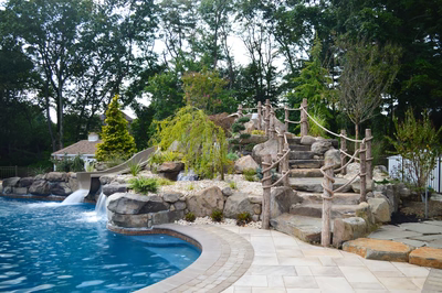 Genale C - Manalapan, NJ - A backyard with a swimming pool, a waterfall, and a rock climbing wall