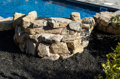 Genesis P - A stone retaining wall next to a swimming pool.