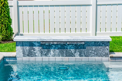 Gibbs B - Avalon, NJ - A pool with a water feature in the middle of it surrounded by green grass and a white fence