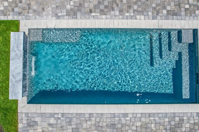 Gibbs H - Avalon, NJ - A rectangular swimming pool surrounded by grass and stone pavers
