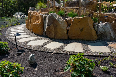 Gikira F - Bethlehem, PA - A rock wall with stepping stones in a garden setting.
