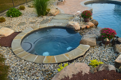 Ginga H - Ringoes, NJ - A backyard with a swimming pool surrounded by rocks and plants.