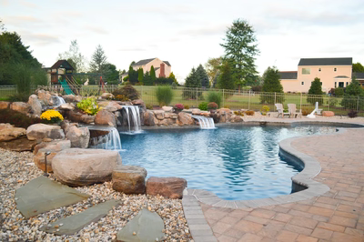 Ginga L - Ringoes, NJ - A backyard with a swimming pool and a waterfall feature