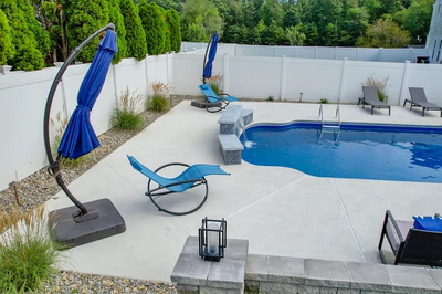 Haifoss N - Sicklerville, NJ - A backyard with a swimming pool surrounded by a white fence and landscaping.