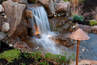 Harvard A - Sewell, NJ - A small waterfall surrounded by rocks and plants in a garden setting