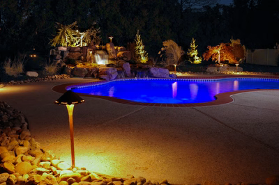 Harvard G - Sewell, NJ - A swimming pool lit up at night with a waterfall in the background