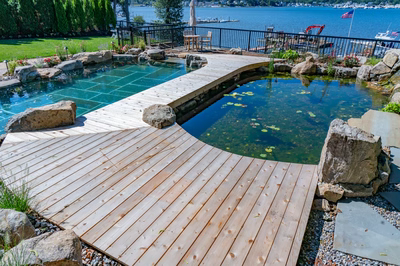 Havasu N - Manasquan, NJ - A wooden walkway leads to a small pond surrounded by rocks and greenery.