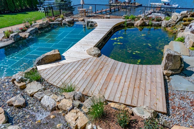 Havasu O - Manasquan, NJ - A wooden walkway over a small pond surrounded by rocks and plants.