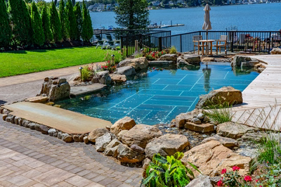 Havasu T - Manasquan, NJ - A beautiful outdoor swimming pool surrounded by lush greenery and flowers.