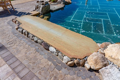 Havasu V - Manasquan, NJ - A stone walkway next to a swimming pool with rocks and pebbles