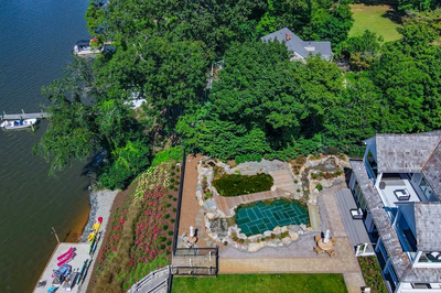 Havasu Z - Manasquan, NJ - A bird's eye view of a house by a lake surrounded by lush greenery